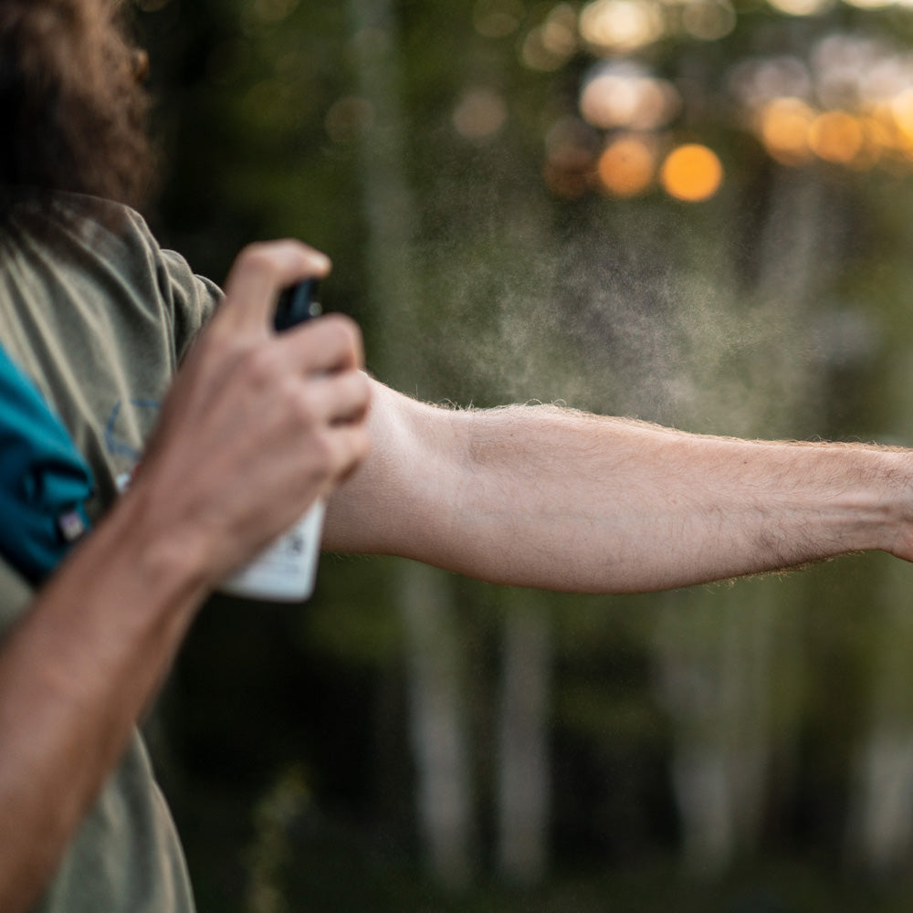 Spraying Tecnu Rash Relief on arm