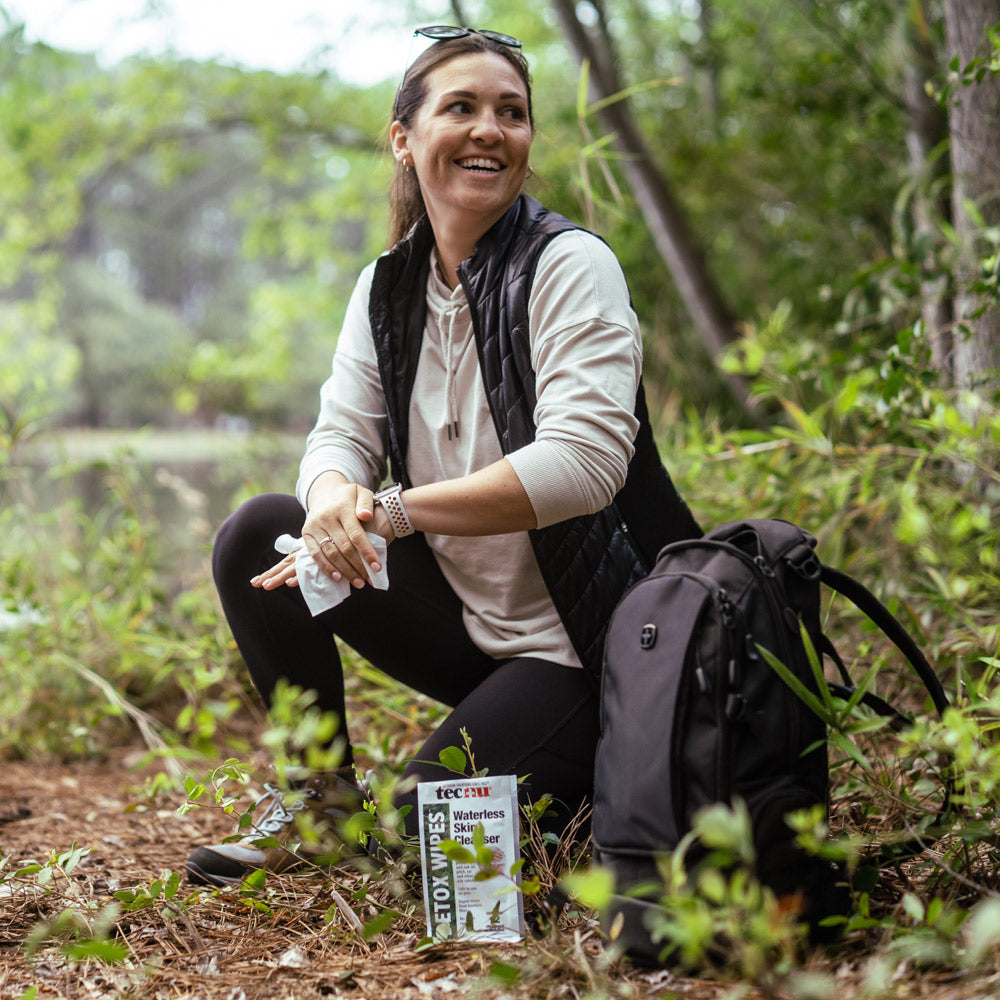 Woman Using Tecnu Detox Wipes in a forest